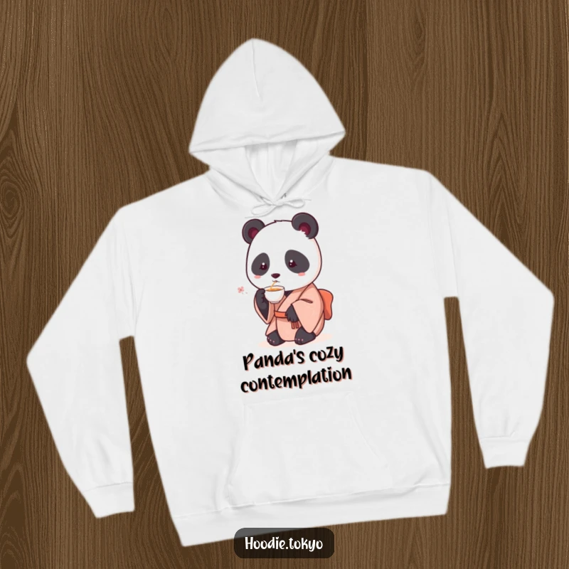 Funny hoodie depicting a round panda wearing a kimono, delicately sipping tea, exuding a sense of peaceful humor and warmth.